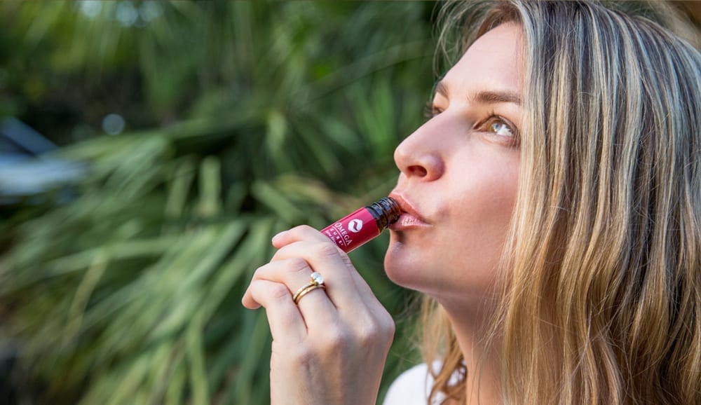 Woman drinking Omega Cure Extra Strength