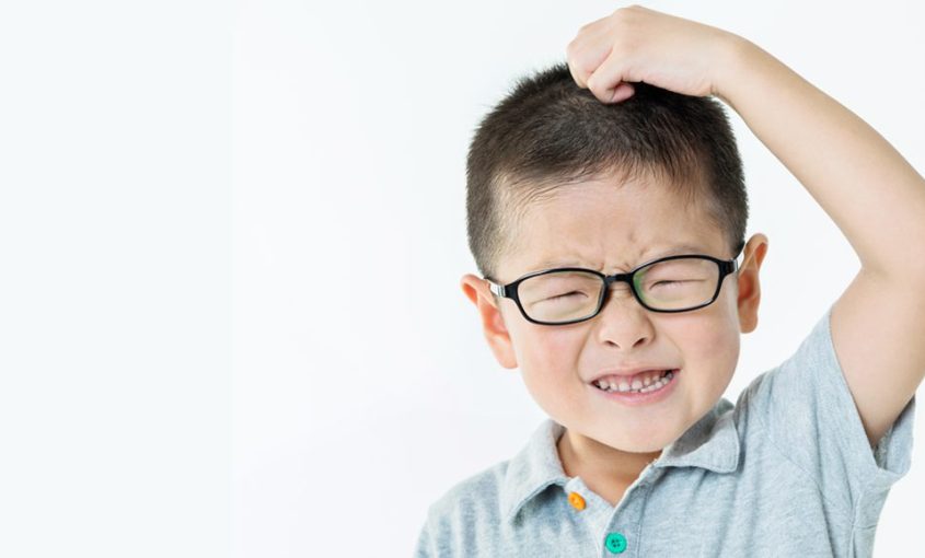 Child scratching his head