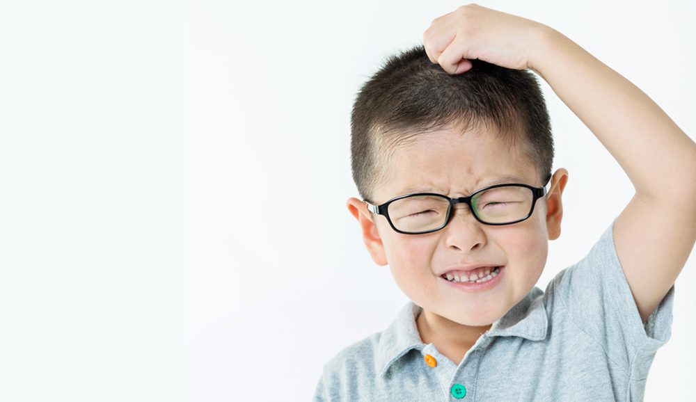 Child scratching his head