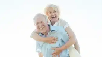Happy senior couple smiling outdoors, symbolizing vitality and well-being in older age, highlighting the benefits of proper iron intake for aging adults
